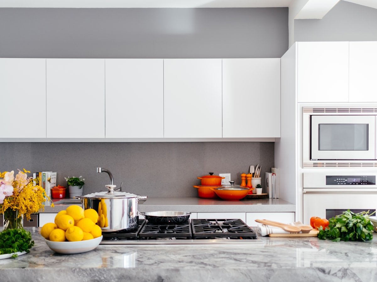 Refreshed residential kitchen with clean cabinetry, stone counters, and warm finishing touches